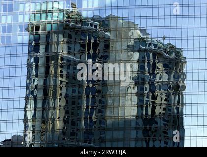 Gespiegelte Reflexionen: Städtische Symmetrie eines Gebäudes, das ein anderes reflektiert Stockfoto