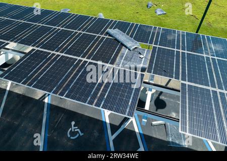 Ausfall der Photovoltaik-Technologie, die in die städtische Infrastruktur integriert ist. Hurrikan-Windschäden an Solarpaneelen, die als Schattendach über dem Parkplatz installiert sind Stockfoto