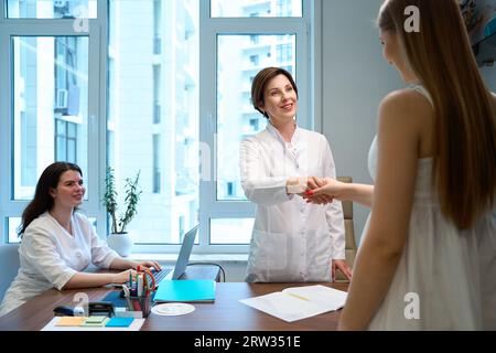 Der Fruchtbarkeitsarzt begrüßt den Patienten in einem hellen Büro Stockfoto