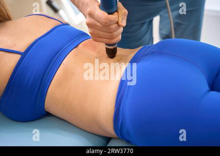 Qualifizierter Physiotherapeut, der extrakorporale Stosswellentherapie durchführt Stockfoto