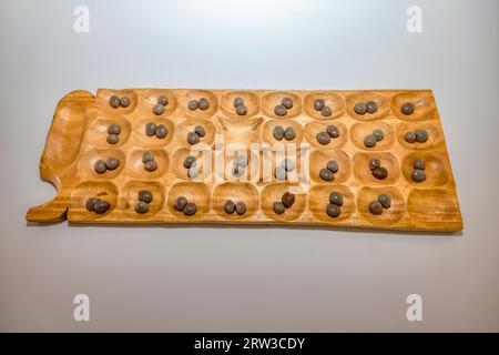 Mancala afrikanisches Brettspiel aus Holz, gespielt mit Steinmarmeln, rundenbasierte Strategiespiele für zwei Spieler, gespielt mit kleinen Steinen, Bohnen oder s Stockfoto