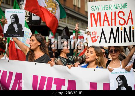 Rom, Italien. September 2023. Eine Frau unter iranischer Flagge zeigt das Foto von Mahsa Amini während der Demonstration zum Gedenken an ihren Tod in Rom. Mahsa Amini wurde am 13. September 2022 von der religiösen Polizei in Teheran verhaftet, weil das Gesetz über die obligatorische Verhüllung nicht eingehalten wurde. Sie starb unter verdächtigen Umständen nach drei Tagen im Koma am 16. September 2022 im Alter von 22 Jahren. Quelle: ZUMA Press, Inc./Alamy Live News Stockfoto