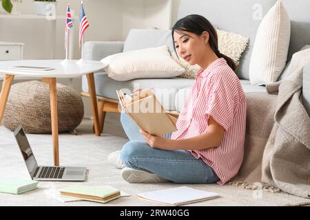 Schöne asiatische Frau, die zu Hause online Englisch lernt Stockfoto