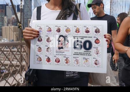 Hunderte von Menschen versammeln sich und marschieren am 16. September 2023 über die Brooklyn Bridge in New York, an einem Jahrestag der Ermordung von Mahsa Jina Amini im Iran, nachdem sie den Hijab angeblich nicht getragen haben Stockfoto