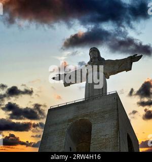 Cristo Rei, Christusstatue mit ausgestreckten Armen, Silhouette gegen den Abendhimmel, Almada, in der Nähe von Lissabon, Portugal Stockfoto