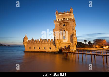 Der Belem-Turm (Portugiesisch: Torre de Belem) am Tejo erleuchtete in der Abenddämmerung in Lissabon, Portugal Stockfoto