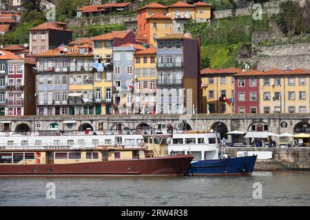 Historische Häuser und Passagierboote am Ufer des Flusses Douro in der Stadt Porto in Portugal Stockfoto