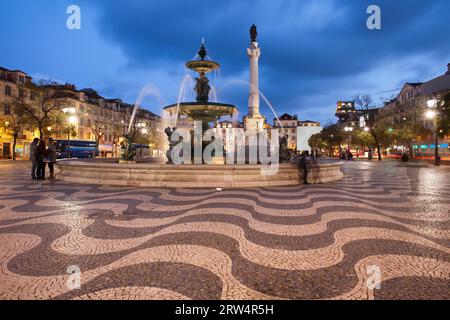 Brunnen und Säule des Dom Pedro IV auf dem Rossio-Platz bei Nacht in Lissabon, Portugal Stockfoto