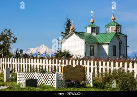 Russische orthodoxe Kirche die Verklärung unseres Herrn und Friedhof, Ninilchik, mit Vulkan in der Stockfoto