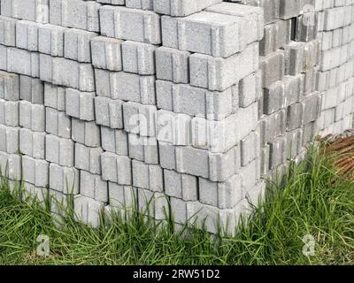 Isolierter Haufen von grauen Bausteinen. Ordentlich auf Gras gestapelt. Hausbau. Baustellenmaterialien. Grundstruktur Stockfoto