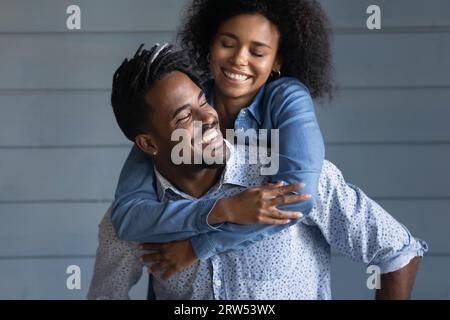 Aufgeregter afroamerikanischer Mann Schweinefleischbegleiterin Frau auf grauem Hintergrund Stockfoto