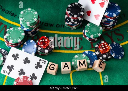 Holzwürfel, auf denen Poker-Spielkarten und Chips auf einem Pokertisch abgelegt werden. Poker-Konzept Stockfoto