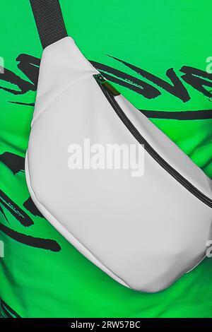 Nahaufnahme weiß, abstrakt, Taille oder Schultertasche, Objekt, Attribut von Stil und Mode auf grünem Hintergrund. Stockfoto