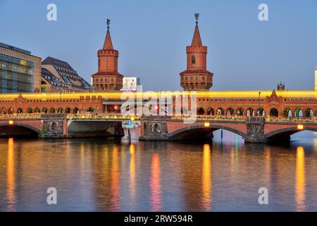 Die schöne Oberbaumbruecke in Berlin mit einer gelben U-Bahn in der Abenddämmerung Stockfoto