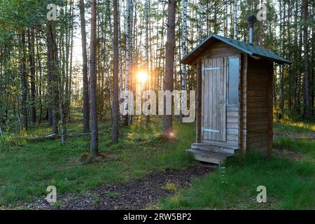 Schöne kleine öffentliche Toilette aus Holz in der Nähe des wunderschönen Waldweges auf dem Mannikjarve-Wanderweg in üppigem Kiefernwald im Endla-Naturschutzgebiet in Estland Stockfoto