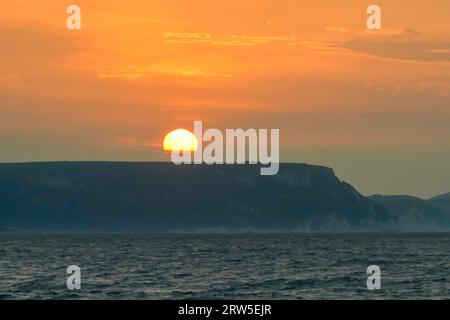 Weymouth, Dorset, Großbritannien. September 2023. Wetter in Großbritannien. Die Wolken leuchten orange bei Sonnenaufgang über der Jurassic Coast nach einer Nacht voller Gewitter in Weymouth in Dorset. Bildnachweis: Graham Hunt/Alamy Live News Stockfoto