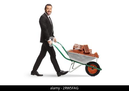 Geschäftsmann schiebt eine Schubkarre mit Ziegeln isoliert auf weißem Hintergrund Stockfoto