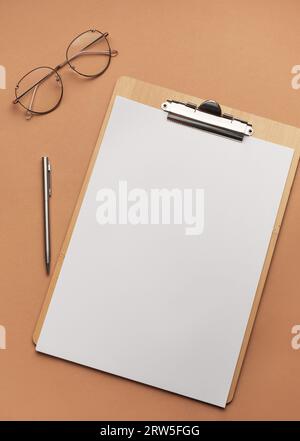 Klemmbrett mit leerem Blatt und Brille, Arbeitsplatz. Stockfoto