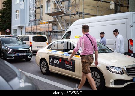 München, Deutschland. September 2023. Wiesnbesucher steigen in ein fahrendes Taxi. . - Besucher betreten ein Taxi. Hunderttausende besuchen das Oktoberfest 2023 am 16. September 2023 in München. Es ist die 188. Auflage des größten Volksfestes der Welt. 600 Polizeibeamte werden verpflichtet sein, die Wiesn, die Besucher, die Unternehmen rund um und Credit: SIPA USA/Alamy Live News zu sichern Stockfoto