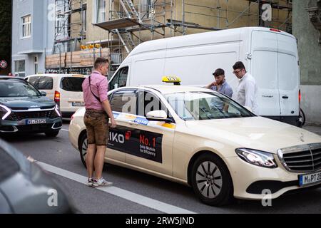 München, Deutschland. September 2023. Wiesnbesucher steigen in ein fahrendes Taxi. . - Besucher betreten ein Taxi. Hunderttausende besuchen das Oktoberfest 2023 am 16. September 2023 in München. Es ist die 188. Auflage des größten Volksfestes der Welt. 600 Polizeibeamte werden verpflichtet sein, die Wiesn, die Besucher, die Unternehmen rund um und Credit: SIPA USA/Alamy Live News zu sichern Stockfoto