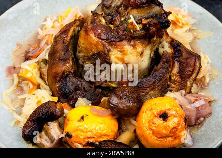 Schweineknie in Sauerkraut und Äpfeln geröstet. Stockfoto