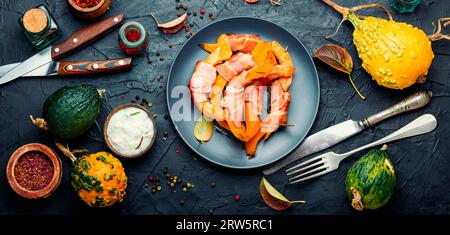 Geröstete hokkaido-Kürbisstücke in Speck verpackt. Stockfoto