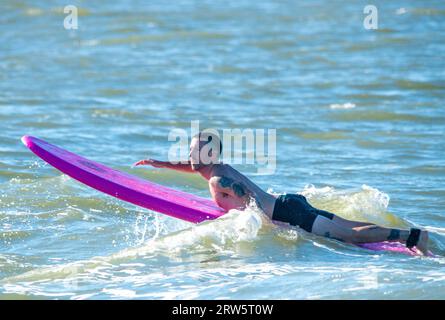 Cape May, Usa. September 2023. Surfer versuchen, einige Wellen zu reiten, die Überreste des Hurrikans Lee sind, während die Leute das warme Wetter am Samstag, den 16. September 2023 am Cove Beach in Cape May, New Jersey genossen. Die Temperaturen lagen am letzten Wochenende vor Herbst in den 80er Jahren. William Thomas Cain/Alamy Live News Stockfoto