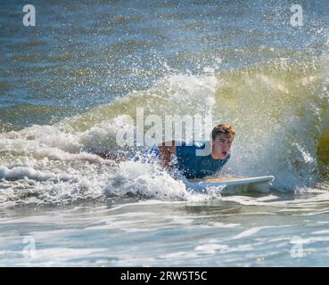 Cape May, Usa. September 2023. Surfer versuchen, einige Wellen zu reiten, die Überreste des Hurrikans Lee sind, während die Leute das warme Wetter am Samstag, den 16. September 2023 am Cove Beach in Cape May, New Jersey genossen. Die Temperaturen lagen am letzten Wochenende vor Herbst in den 80er Jahren. William Thomas Cain/Alamy Live News Stockfoto