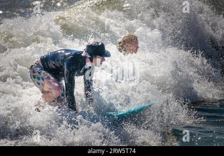 Cape May, Usa. September 2023. Surfer versuchen, einige Wellen zu reiten, die Überreste des Hurrikans Lee sind, während die Leute das warme Wetter am Samstag, den 16. September 2023 am Cove Beach in Cape May, New Jersey genossen. Die Temperaturen lagen am letzten Wochenende vor Herbst in den 80er Jahren. William Thomas Cain/Alamy Live News Stockfoto