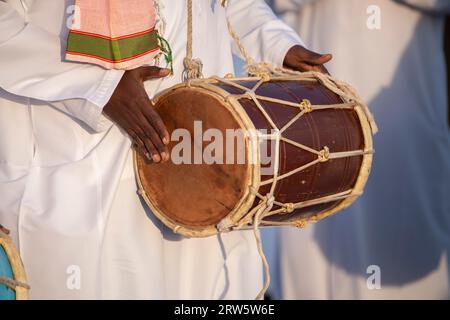 Nahaufnahme eines Musikers, der mit einem Dholak während eines Dhow-Festivals spielt. Stockfoto