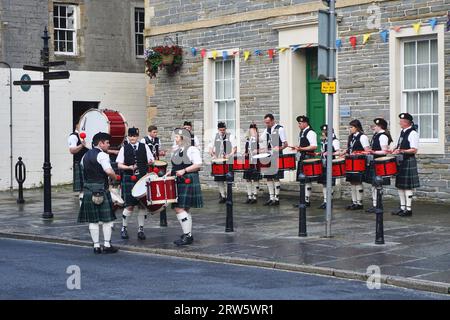 Männliche und weibliche Trommler der Kirkwall City Pipe Band wärmen sich auf, bevor sie sich den Dudelsackern der Gruppe anschließen, um im nahegelegenen Stadtzentrum aufzutreten Stockfoto