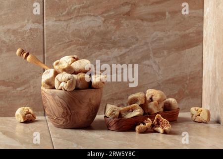 Süße getrocknete Feigen in einer Holzschale auf einem Küchentisch aus Keramik. Speicherplatz kopieren. Stockfoto