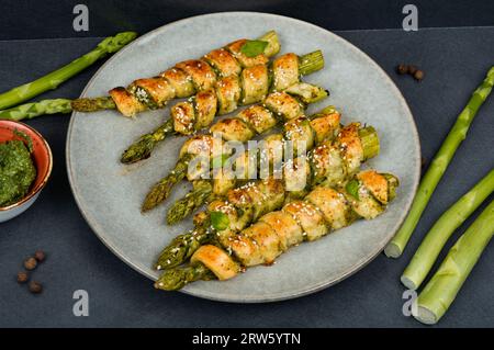 Vegetarischer grüner Spargel in Blätterteig mit Pesto-Sauce gebacken.gesunde Ernährung. Stockfoto