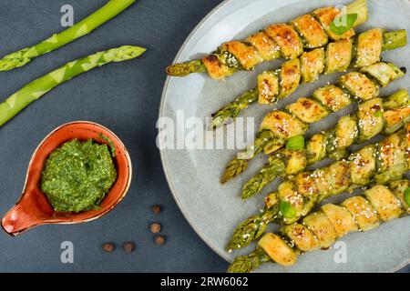 Vegetarischer grüner Spargel in Teig gebacken mit Basilikum-Pesto-Sauce. Stockfoto