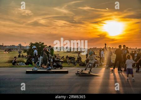 Tempelhofer Feld, Menschen bei Freizeitaktivitäten auf der Startbahn und Landebahn auf dem ehemaligen Flughafen Berlin-Tempelhof, Sonnenuntergang, BE Stockfoto