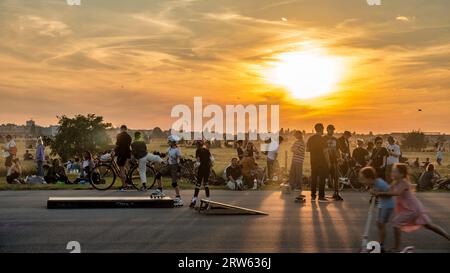 Tempelhofer Feld, Menschen bei Freizeitaktivitäten auf der Startbahn und Landebahn auf dem ehemaligen Flughafen Berlin-Tempelhof, Sonnenuntergang, BE Stockfoto