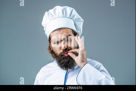 Kochmütze. Professioneller Küchenchef zeigt Zeichen für köstlich. Koch, Koch, der köstliche Geste zubereitet, indem er die Finger küsst. Bärtiger Koch, Köche oder Bäcker Stockfoto