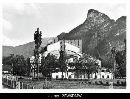 Das Passionsspiel-Theater Oberammergau mit dem Kofel dahinter. Nummer 10 in einem Vintage-Fotoset, das möglicherweise aus den 1930er Jahren stammt Stockfoto