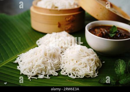 Idiyappam mit Hühnercurry | Kerala gedämpftes Frühstück aus Reismehl Stockfoto