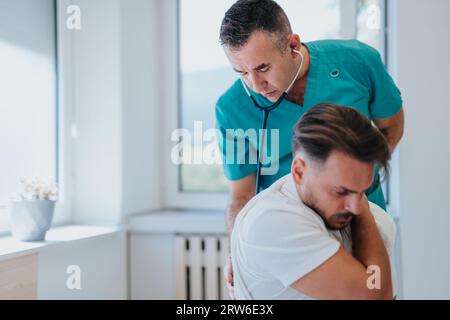 Ein Oberarzt bietet medizinische Versorgung für einen jungen männlichen Patienten in einer gut ausgestatteten Klinik, Blutdruck zu überprüfen und Gesundheitsprobleme zu diskutieren. Stockfoto