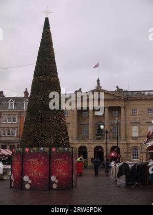 Newark-on-Trent, Nottinghamshire, Großbritannien - 3. Dezember 2022: Vertikale Aufnahme des konischen Weihnachtsbaums auf dem Marktplatz, gegenüber dem Rathaus. Stockfoto