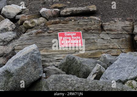 „Danger Falling Rocks“-Schild am Strand in Staithes, North Yorkshire, Großbritannien Stockfoto