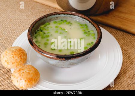 Cremige Gemüsesuppe mit Käsebrot. Pürierte Selleriesuppe mit grüner Erbse in einer Schüssel aus nächster Nähe Stockfoto