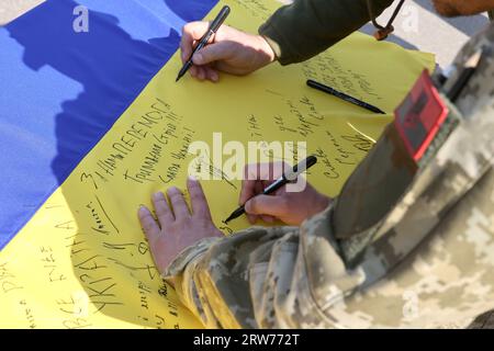 Nicht exklusiv: PECHENIHY, UKRAINE - 12. SEPTEMBER 2023 - Soldaten unterzeichnen eine ukrainische Flagge während der Zeremonie zum ersten Jahrestag der lib Stockfoto