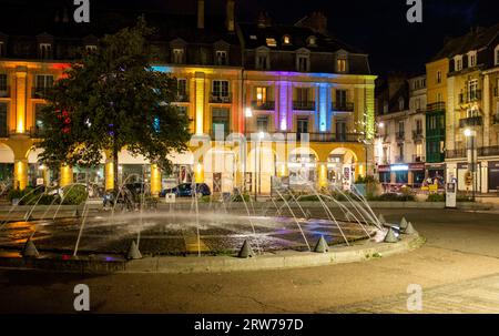 Gebäude und Brunnen, die nachts in Dieppe beleuchtet werden, ist ein Fischerhafen an der Normandie Küste von Nordfrankreich Stockfoto