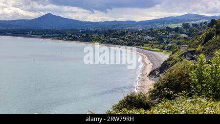 Blick von der Spitze des „Killiney Hill“ in Richtung Killiney Beach und DART-Schiene. Wicklow-Küste und Berge in der Ferne. Dublin, Irland Stockfoto