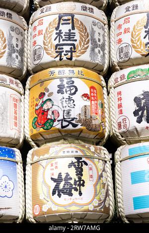 Stapel von bunten japanischen Sake-Fässern, die von Destillatoren am Südeingang des Meiji Jingu in einem 170 Hektar großen Wald in Shibuya, Tokio, Japan, gespendet wurden. Der Shinto-Schrein ist den Geistern von Kaiser Meiji und seiner Frau, Kaiserin Shoken, gewidmet. Stockfoto