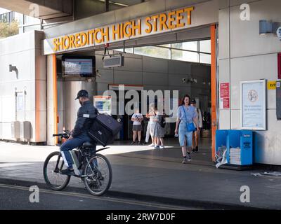 Shoreditch High Street TFL, überirdischer Bahnhof, London, mit Radfahrern und Pendlern, die den Ausgang verlassen Stockfoto