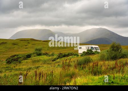 Caravan parkte zwischen grünen Wiesen neben den Bergen des Glencoe Valley, Schottland Stockfoto