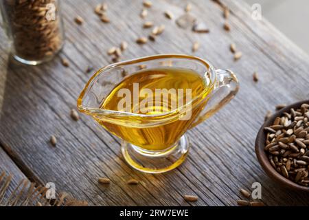Mariendistelöl in einer Glaskanne mit Samen auf einem Tisch Stockfoto